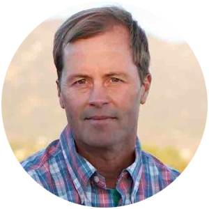 Headshot of a man in a plaid collared shirt