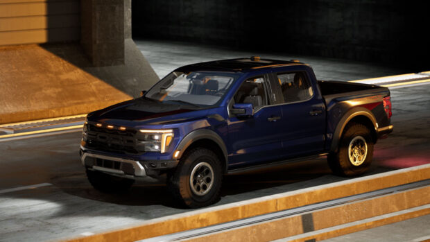 Aerial side view of a dark blue Ford Raptor exiting a tunnel