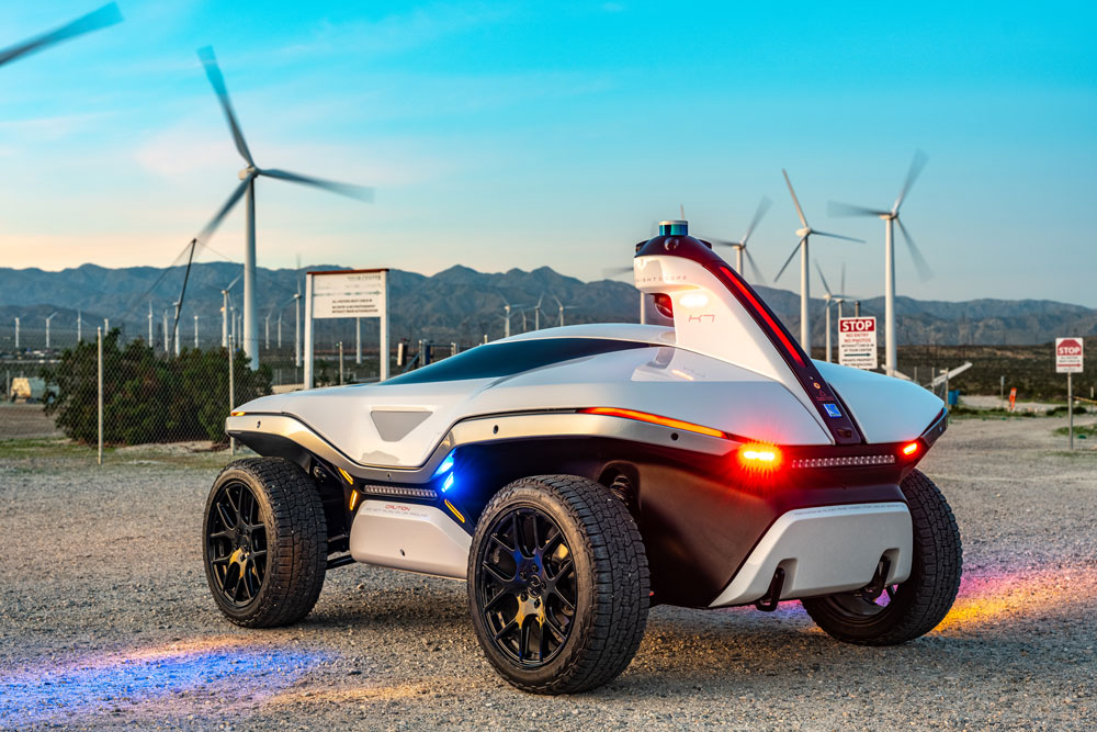 Rear left view of knightscope k7 security robot with windmills and blue skies in the background