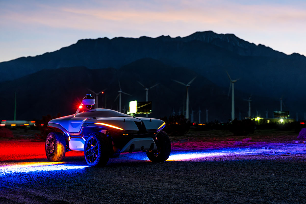 Dark photo of lit up security vehicle with red and blue lights in front of a mountain